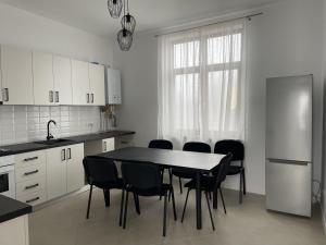 eine Küche mit einem Tisch und Stühlen sowie einem Kühlschrank in der Unterkunft Racers' Home in Balş