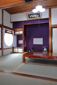 Habitación con mesa y pared púrpura. en Lien Tono en Tōno