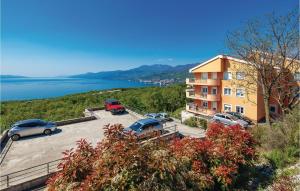 a building with cars parked in a parking lot next to the water at Stunning Apartment In Kastav With House Sea View in Kastav