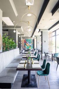 une grande salle à manger avec une grande table et des chaises vertes dans l'établissement Hotel Rogge, à Reşiţa