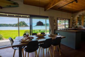 een keuken en eetkamer met een tafel en stoelen bij Absolute Beach front-Tutukaka Harbour in Tutukaka