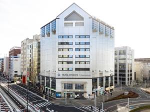 a rendering of a building in a city with traffic at HOTEL MYSTAYS Utsunomiya in Utsunomiya