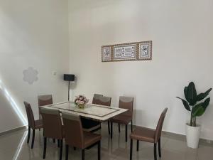 a dining room with a table and chairs at Homestay Sejahtera Pool Pokok Sena in Pokok Sena