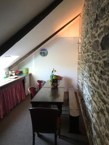 a dining room with a table and a stone wall at Manoir de Parc ar Brun in Tréguier