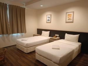una camera d'albergo con due letti e una finestra di AMB LAI LAI HOTEL a Labuan