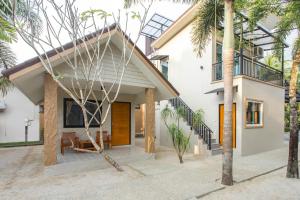 a home with palm trees in front of it at Lightplus Khao Lak in Khao Lak