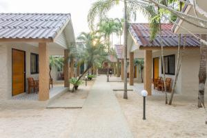 una strada con case, sedie e palme di Lightplus Khao Lak a Khao Lak