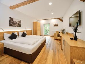 a bedroom with a large bed and a desk at Hofwirthotel in Sankt Martin im Innkreis