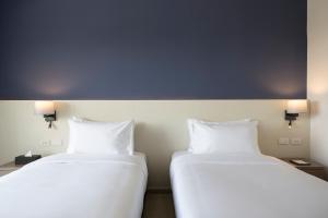 七岩的住宿－Centara Life Cha-Am Beach Resort Hua Hin，两张睡床彼此相邻,位于一个房间里