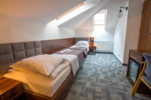 1 dormitorio con 2 camas y TV en Farys - świetna lokalizacja, sauna, jacuzzi, piękne widoki z okien, en Krynica-Zdrój