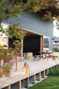 a wooden deck with picnic tables in front of a building at ISHINOMAKI Home Base 石巻ホームベース in Watanoha