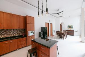 a kitchen with wooden cabinets and a dining room at The Lavana River Villas Lombok in Senggigi