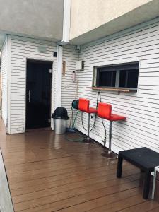 a patio with two red chairs and a grill at Villa Miami in Ashdod