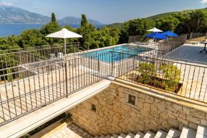 vista sulla piscina con ombrelloni di Villa Gionis a Fiskardho