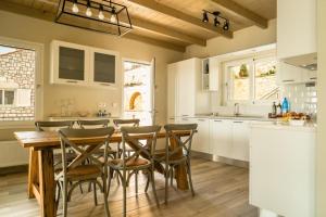a kitchen with a wooden table and chairs at Villa Gionis in Fiskardho
