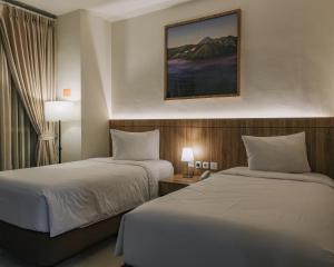 una camera d'albergo con due letti e una foto a parete di Horison Inn Antawirya Semarang a Jatingaleh