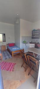 a room with a bed and chairs and a kitchen at "STELIOS & GALINI" in Symi