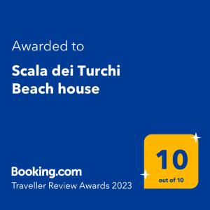 a yellow sign that reads awarded to seala del turkish beach house at Scala dei Turchi Beach house in Realmonte