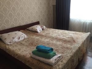 Bett mit Kissen und Handtüchern darüber in der Unterkunft Кабанбай ЦГБ больница in Semei