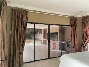 a bedroom with sliding doors leading to a patio at 3 Schnehage Guesthouse in Welkom