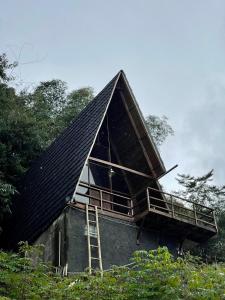 a house with a gambrel roof with a ladder at Villa Bima Syandana Resort in Ciwidey