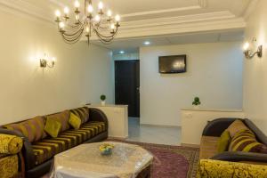 ein Wohnzimmer mit 2 Sofas und einem Kronleuchter in der Unterkunft Grand appartement calme et lumineux + Parking GRATUIT in Casablanca