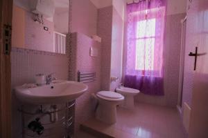 bagno con lavandino, servizi igienici e finestra di Casa Margherita a Sellia Marina