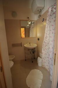 uma casa de banho com um lavatório, um WC e uma cortina de chuveiro. em Casa Margherita em Sellia Marina