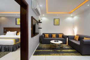a hotel room with a bed and a couch at Mirada Purple Al Waha - Serviced Apartments in Jeddah