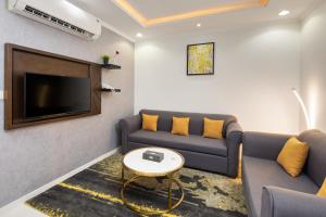 a living room with two couches and a tv at Mirada Purple - Al Waha in Jeddah
