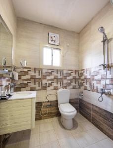 La salle de bains est pourvue de toilettes, d'un lavabo et d'une douche. dans l'établissement Mirada Purple - Al Waha, à Djeddah