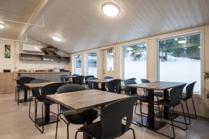 un comedor con mesas, sillas y ventanas en Skillevollen Motell en Mo i Rana