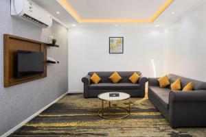 a living room with two couches and a tv at Mirada Purple Al Waha - Serviced Apartments in Jeddah