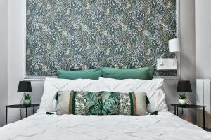 1 dormitorio con 1 cama con un gran papel pintado de flores en Appartement L’Élégant - Idéalement Situé, en Écully