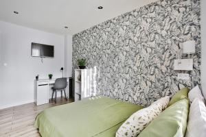 1 dormitorio con 1 cama verde frente a la pared en Appartement L’Élégant - Idéalement Situé, en Écully