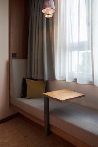 a bed with a table in front of a window at Cocoon Sendlinger Tor in Munich