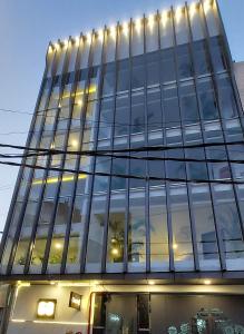 a tall glass building with lights on it at Gallivanto Inn in New Delhi