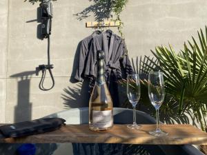 - une bouteille de vin sur une table avec deux verres dans l'établissement 5 Etoiles hébergement insolite de luxe, à Pléneuf-Val-André