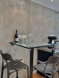 - un bar avec 2 chaises et une table avec des verres à vin dans l'établissement 5 Etoiles hébergement insolite de luxe, à Pléneuf-Val-André