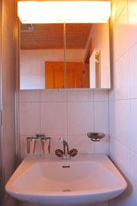 a white sink in a bathroom with a mirror at Chalet Arabesque - Switzerland in Grächen