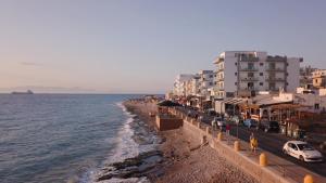 a view of a beach with buildings and the ocean at Sunrise Aparthotel Rhodes in Rhodes Town