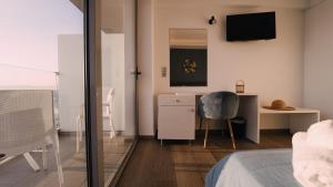a bedroom with a bed and a desk and a chair at Sunrise Luxury Apartments Rhodes in Rhodes Town