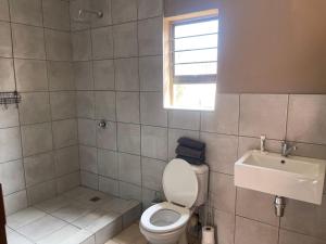 a bathroom with a toilet and a sink at 3 Schnehage Guesthouse in Welkom