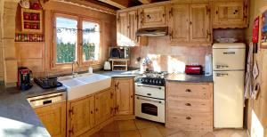 a kitchen with wooden cabinets and a white refrigerator at Alpen Lounge in Servoz