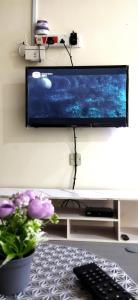 uma televisão de ecrã plano pendurada numa parede por cima de uma mesa em RaiRai Homestay Gambang em Gambang