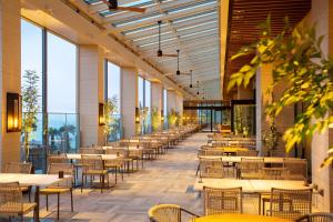 Suginoi Hotel في بيبو: مطعم فارغ بطاولات وكراسي ونوافذ