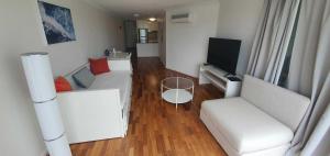 a living room with two white couches and a television at Entire Spacious Apartment in the HEART of Canberra! in Canberra