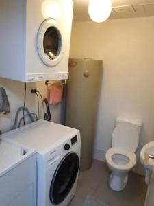 a bathroom with a washing machine and a toilet at Entire Spacious Apartment in the HEART of Canberra! in Canberra
