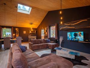 sala de estar amplia con sofá y TV en A L OREE DU BOIS en Ferrières