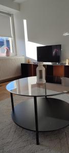 a glass coffee table in a living room with a tv at Core Luxembourg City in Luxembourg